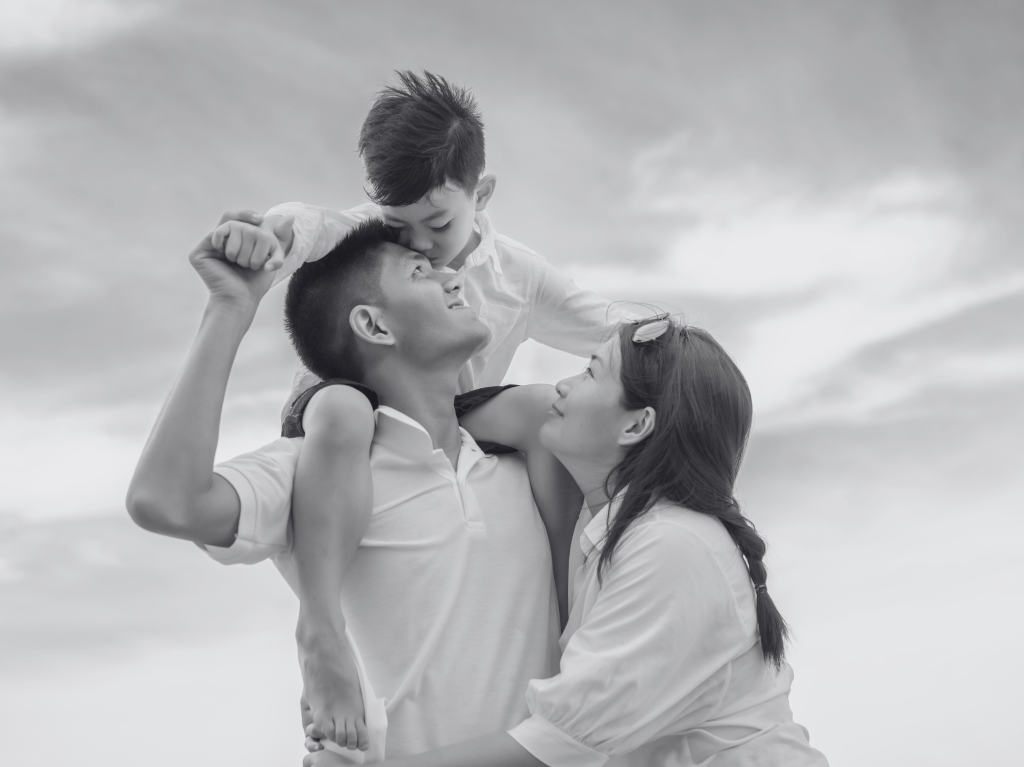 a mother and father smile at their child